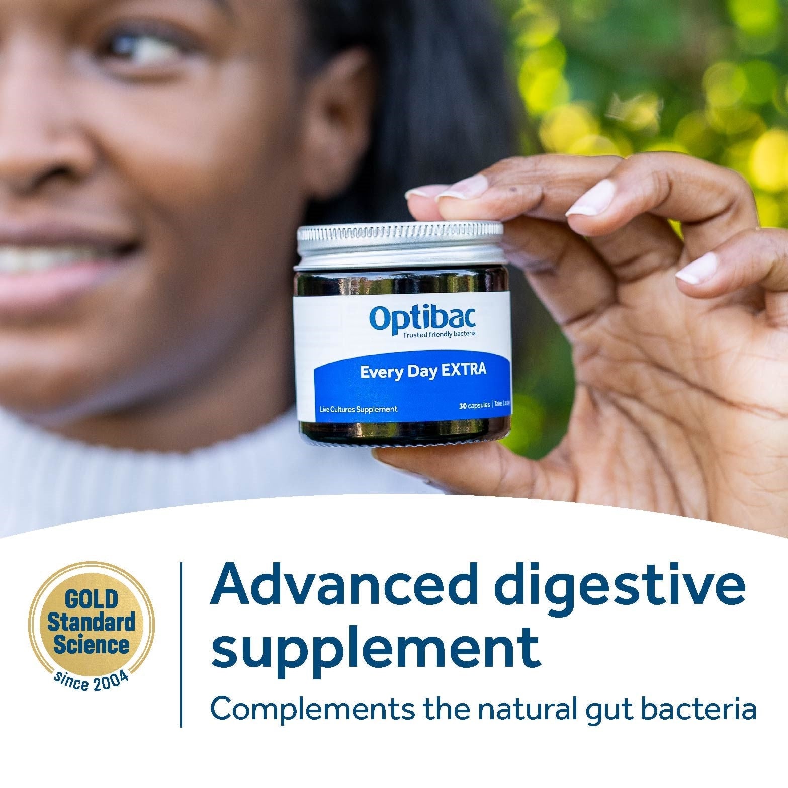 Hand holding Optibac Every Day EXTRA probiotic jar, high-strength digestive supplement.