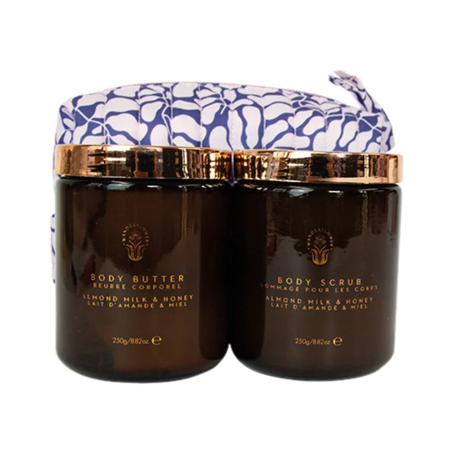 Wanderflower Soft Skin Almond Milk & Honey Body Scrub and Body Butter in amber jars with gold lids and matching gift pouch
