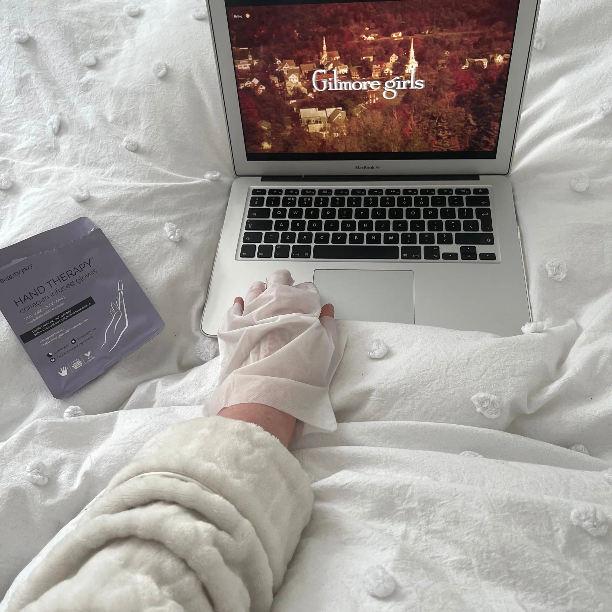 Relaxing beauty routine with BeautyPro Hand Therapy gloves while watching laptop