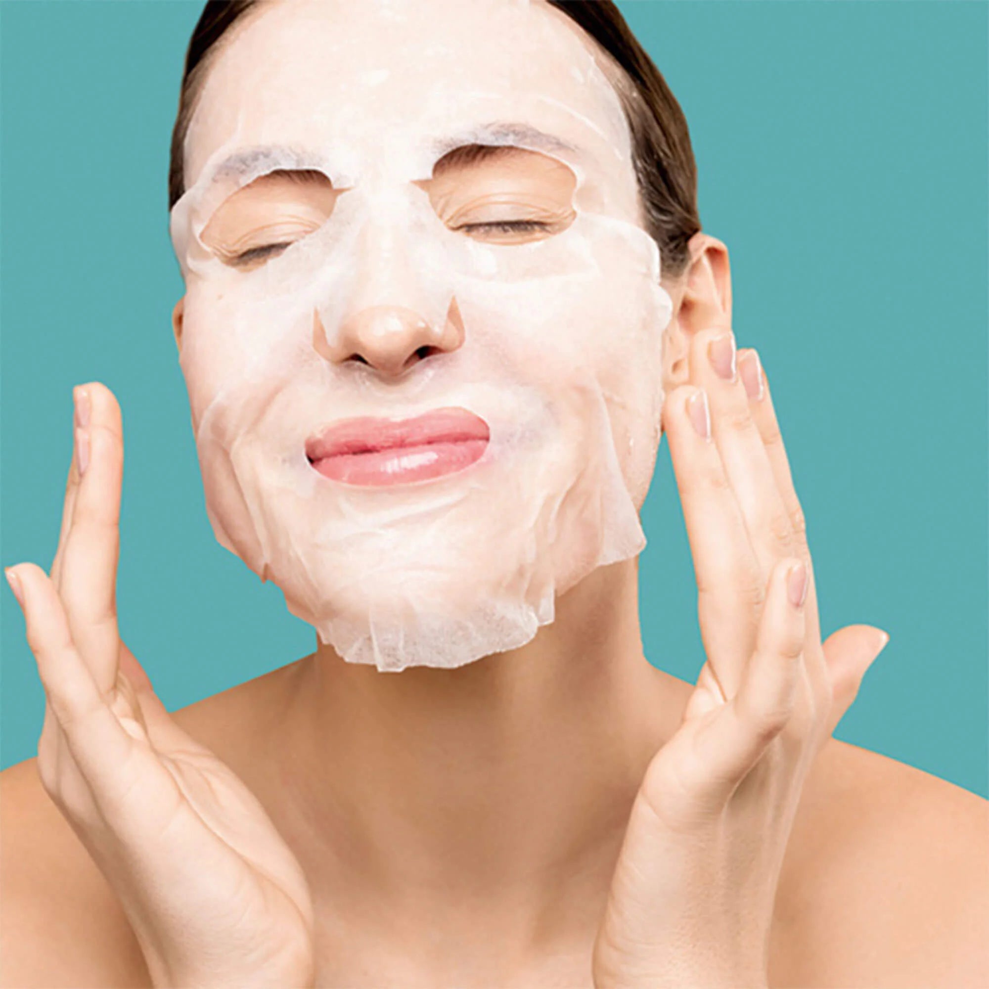 Woman applying the Retinol sheet mask on glowing skin
