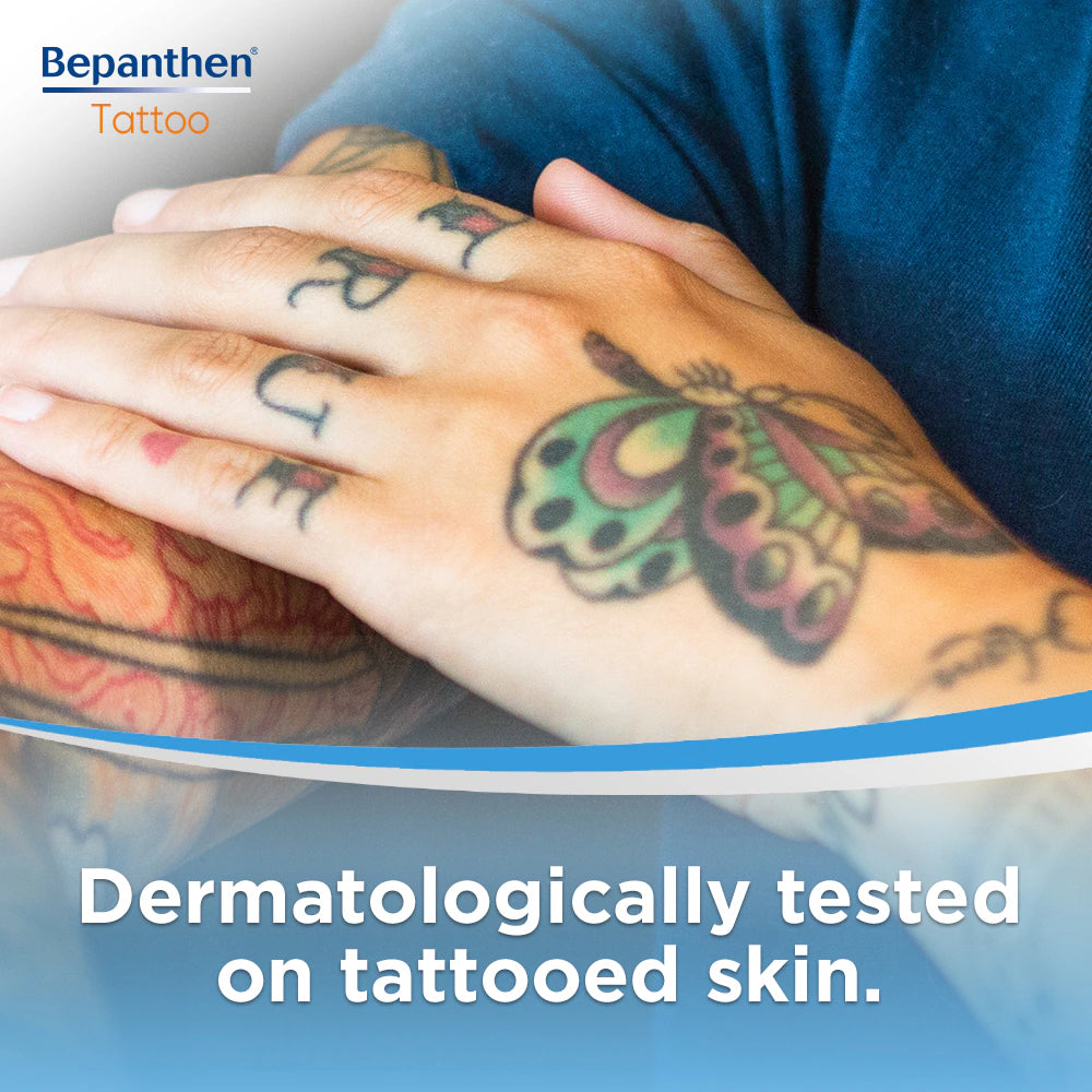 Applying Bepanthen ointment to colourful arm tattoo – protects and moisturises