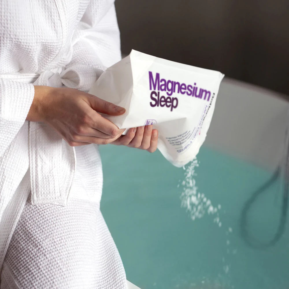 BetterYou Magnesium Sleep bath salts being poured into a relaxing bath