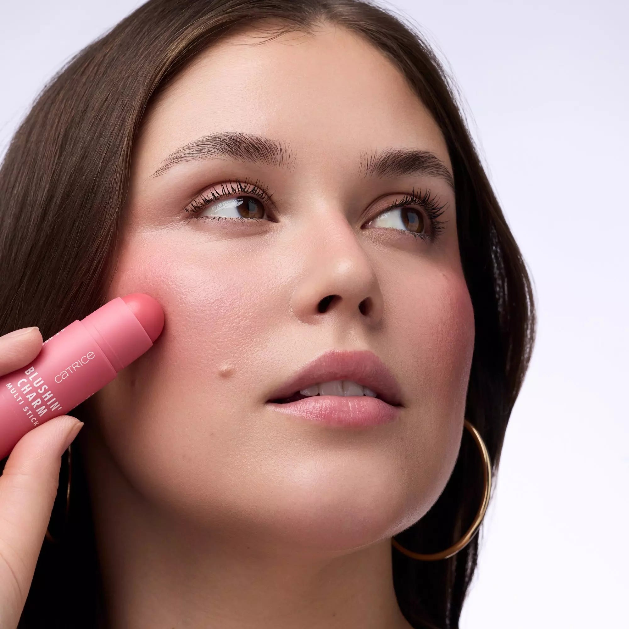Model Applying Catrice Blushin’ Charm Multi Stick Pink Sweetheart to Cheeks