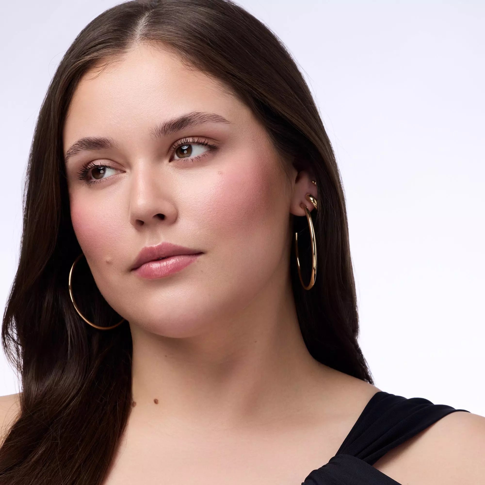 Model with straight brown hair showcasing soft blush look with Catrice Blushin’ Charm Sparkle Lover