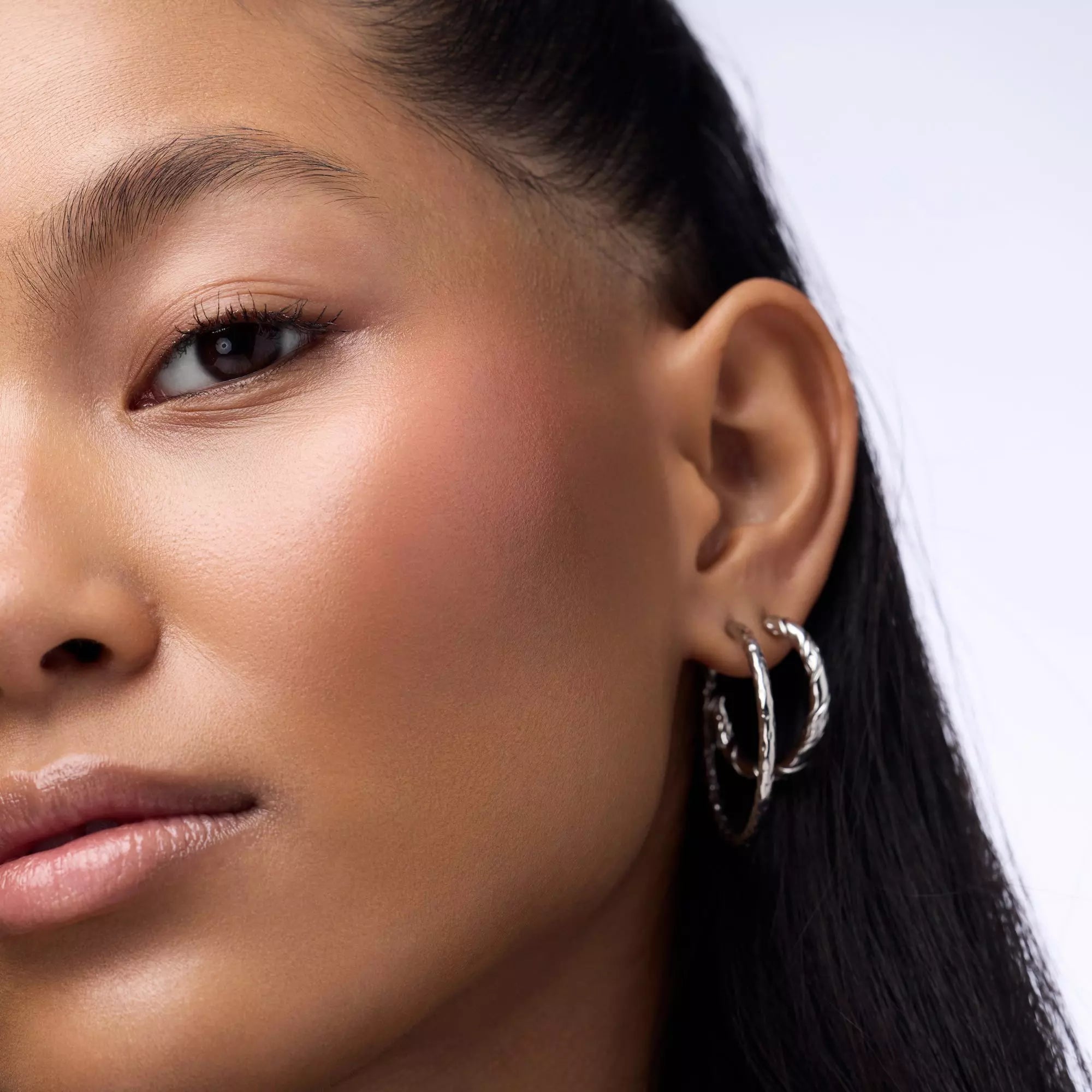 Close-up of model with luminous cheeks wearing Catrice Blushin’ Charm Multi Stick Sparkle Lover