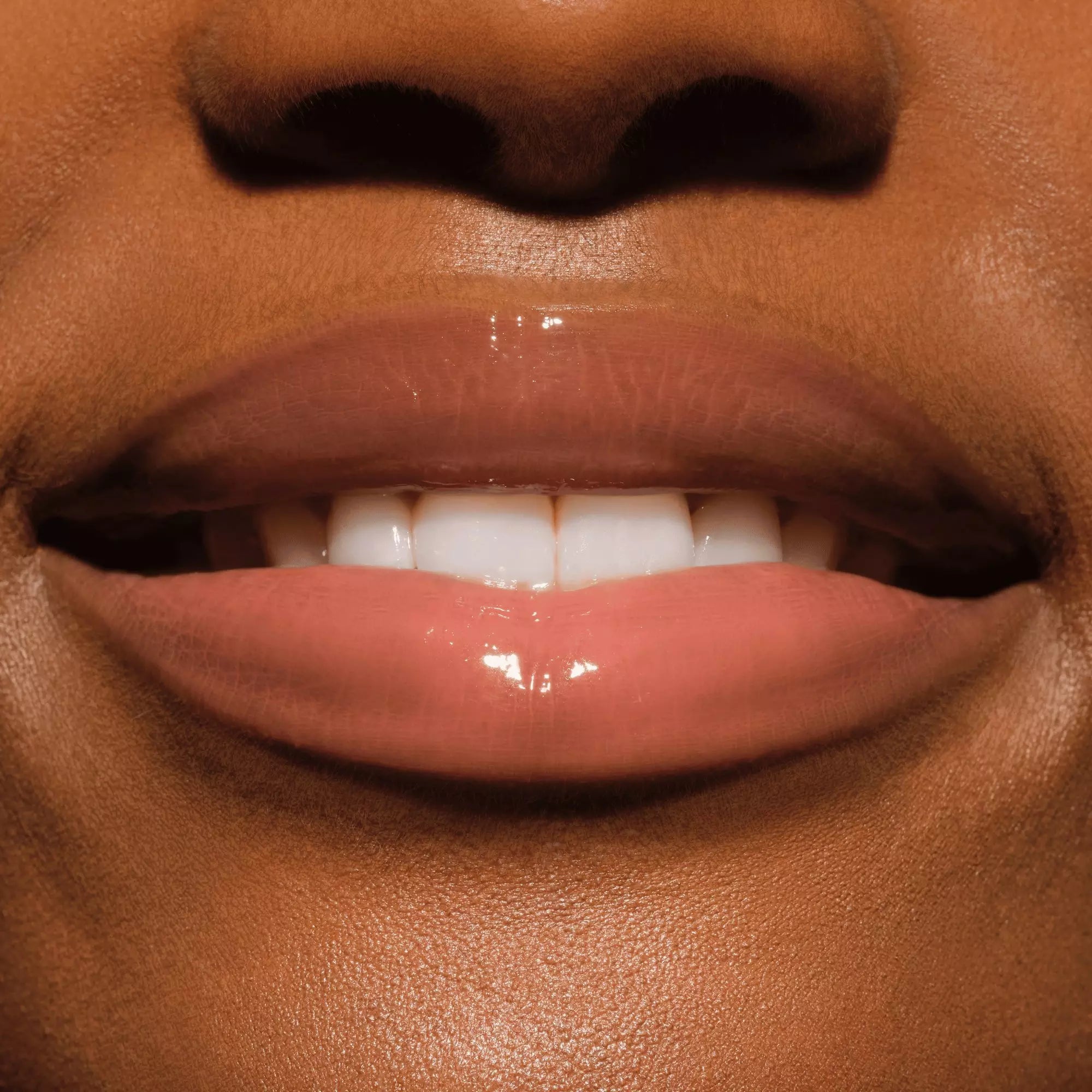Hand applying Catrice Butter Drippin’ Glossy Lip Balm 020 Maple Latte warm nude shade