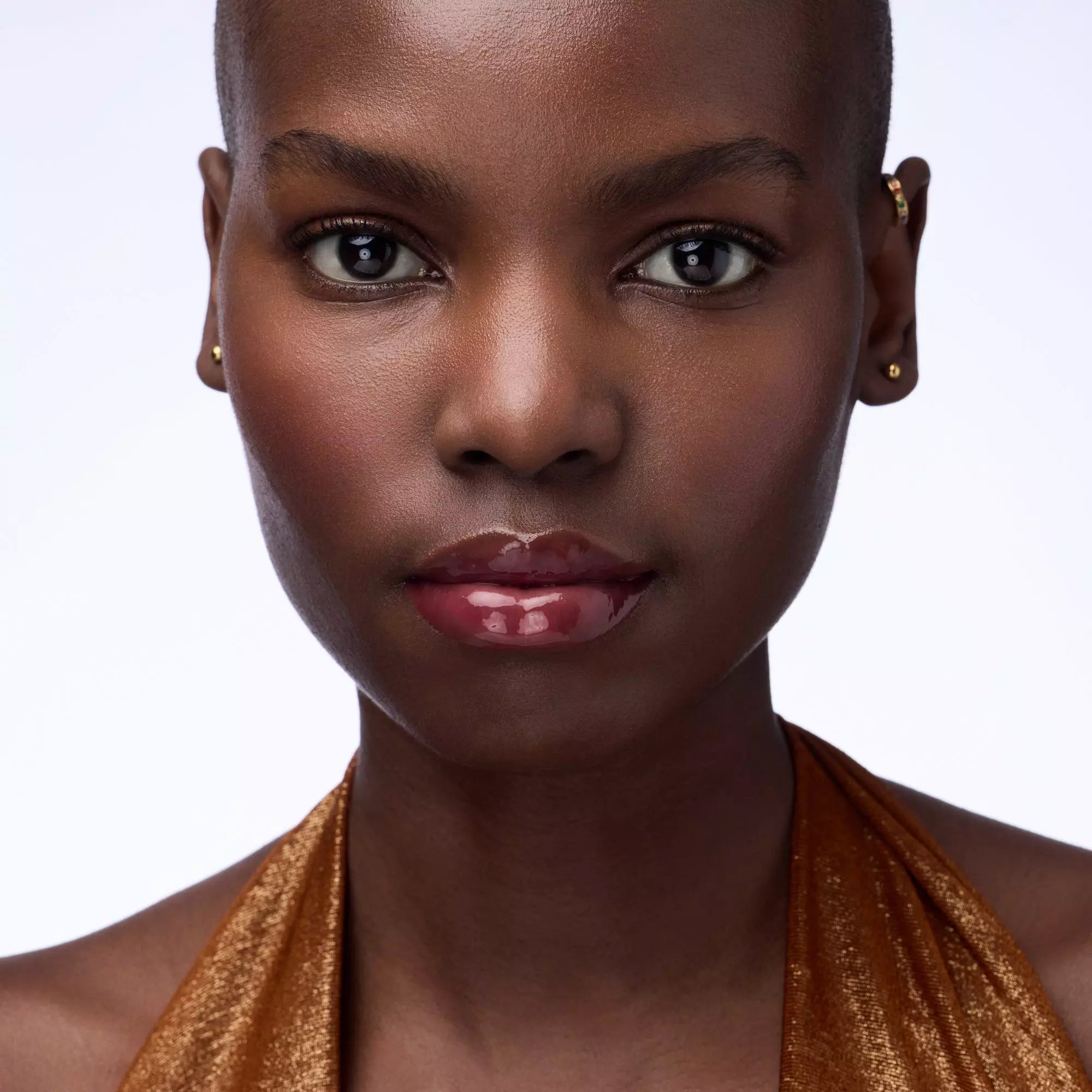 Close-up of Catrice Cherry Delicious glossy lip balm on dark skin
