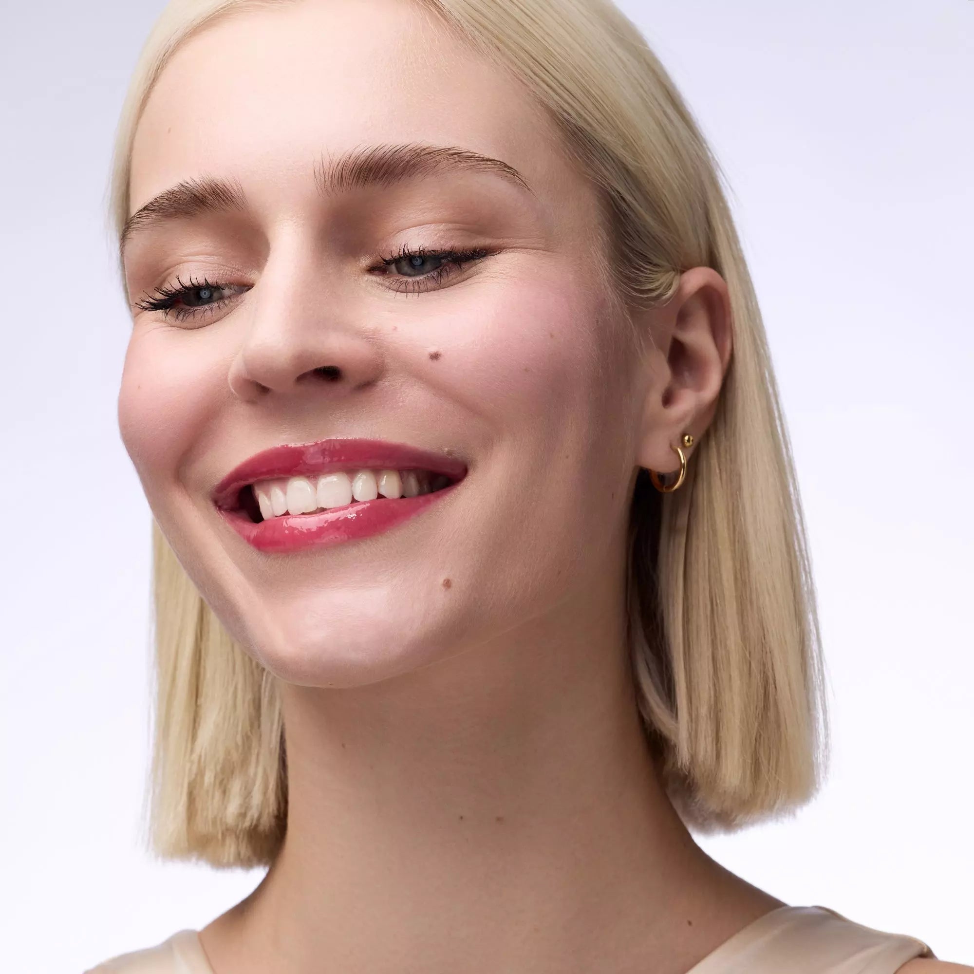 Close-up of Catrice Cherry Delicious glossy lip balm on pale skin 