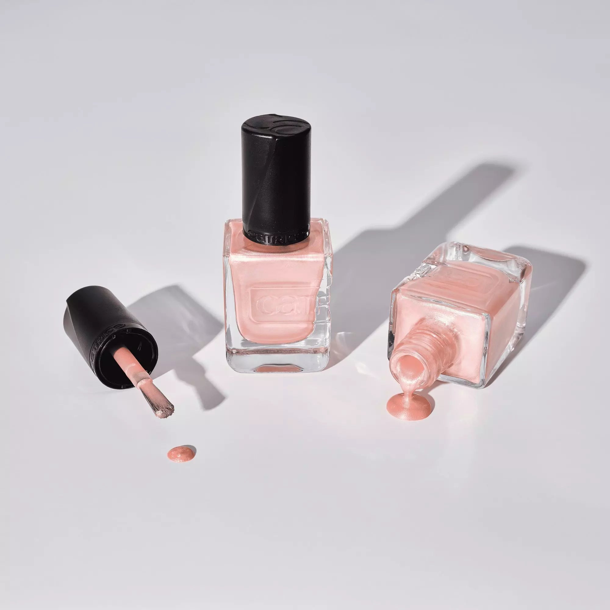 Flatlay of Catrice Gel Affair nude shimmer polish with open bottle and polish spill