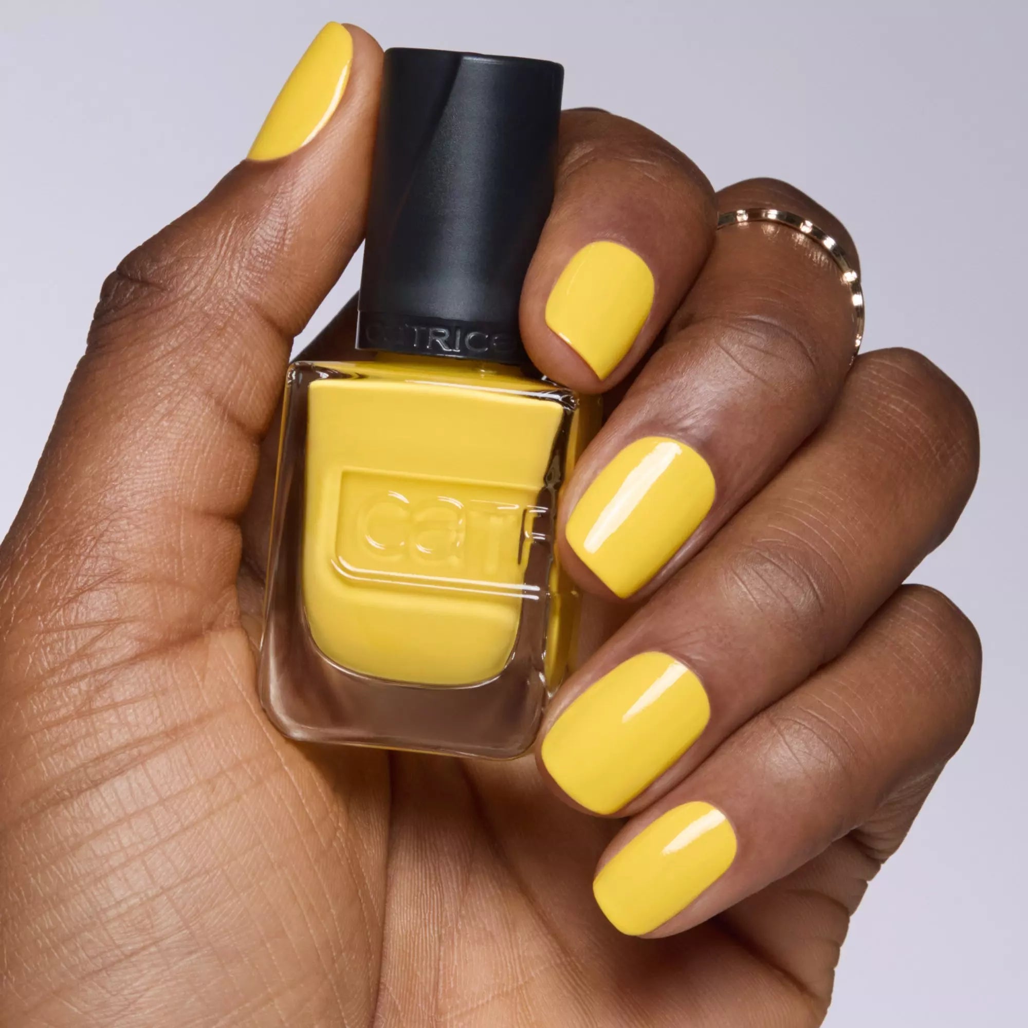 Bright yellow manicure holding Catrice Gel Affair 013 yellow nail polish