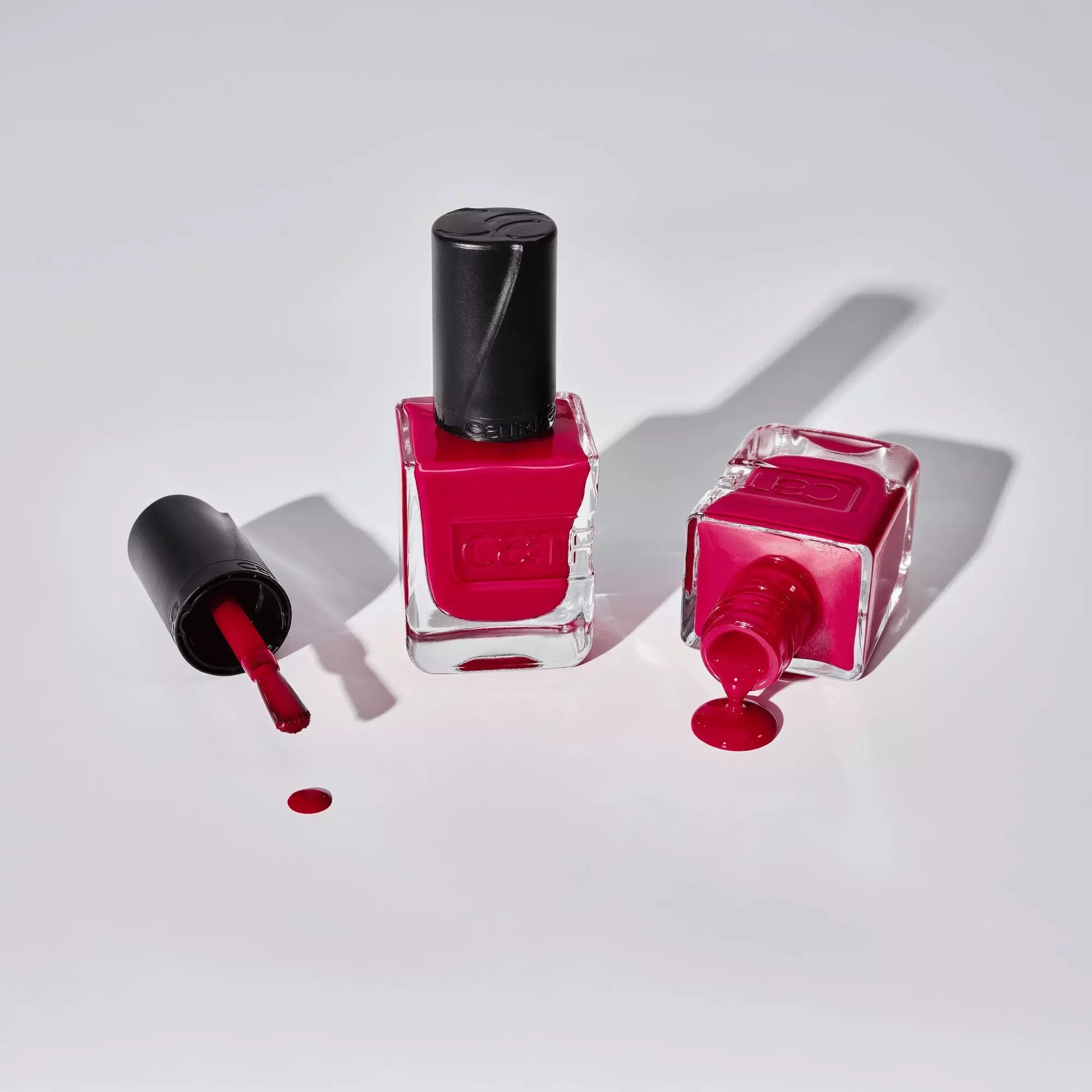 Flat lay of Catrice Gel Affair red nail lacquer – spilled polish and bottle
