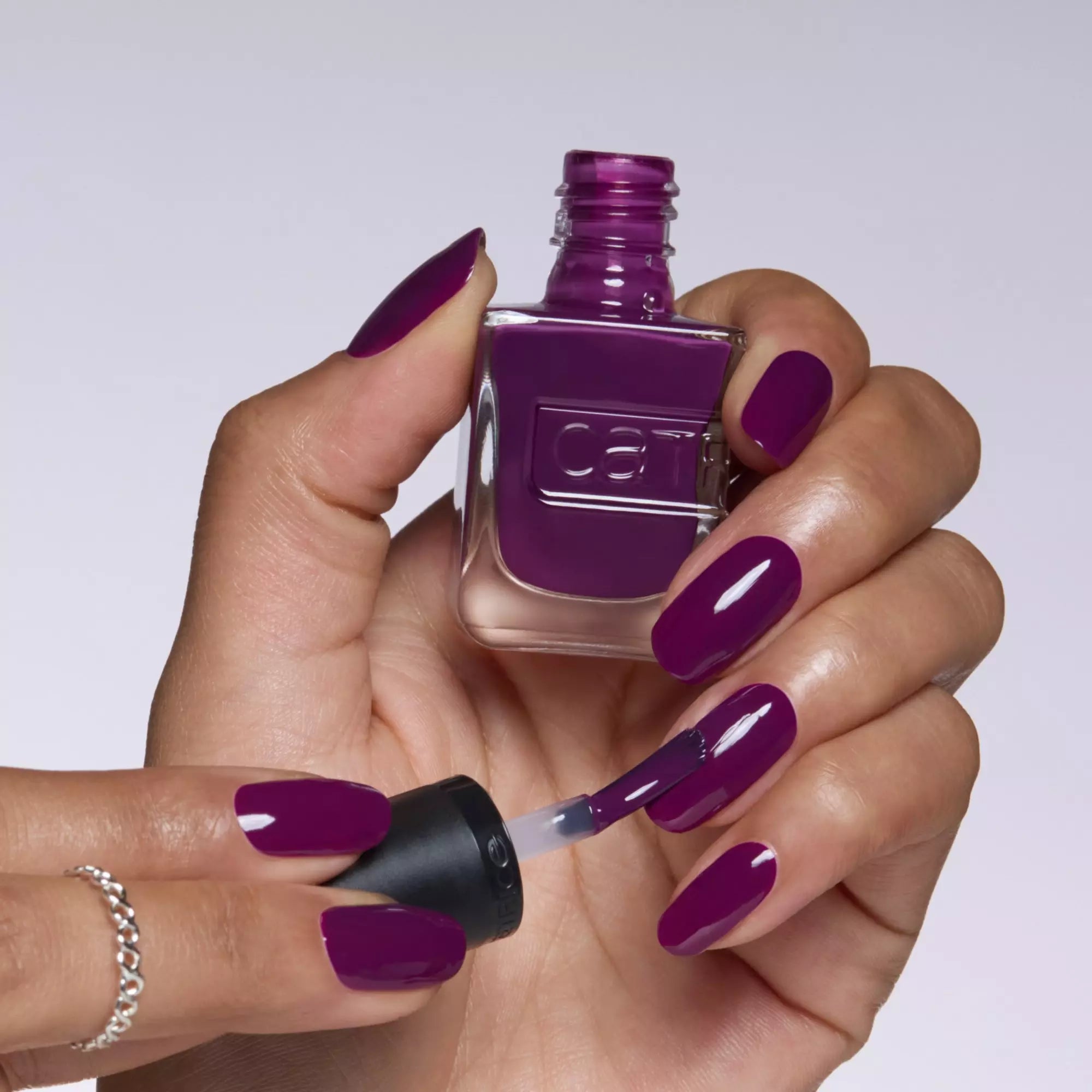 Hand with Catrice Plum-Believable Nails Holding Gel Affair Nail Polish Bottle