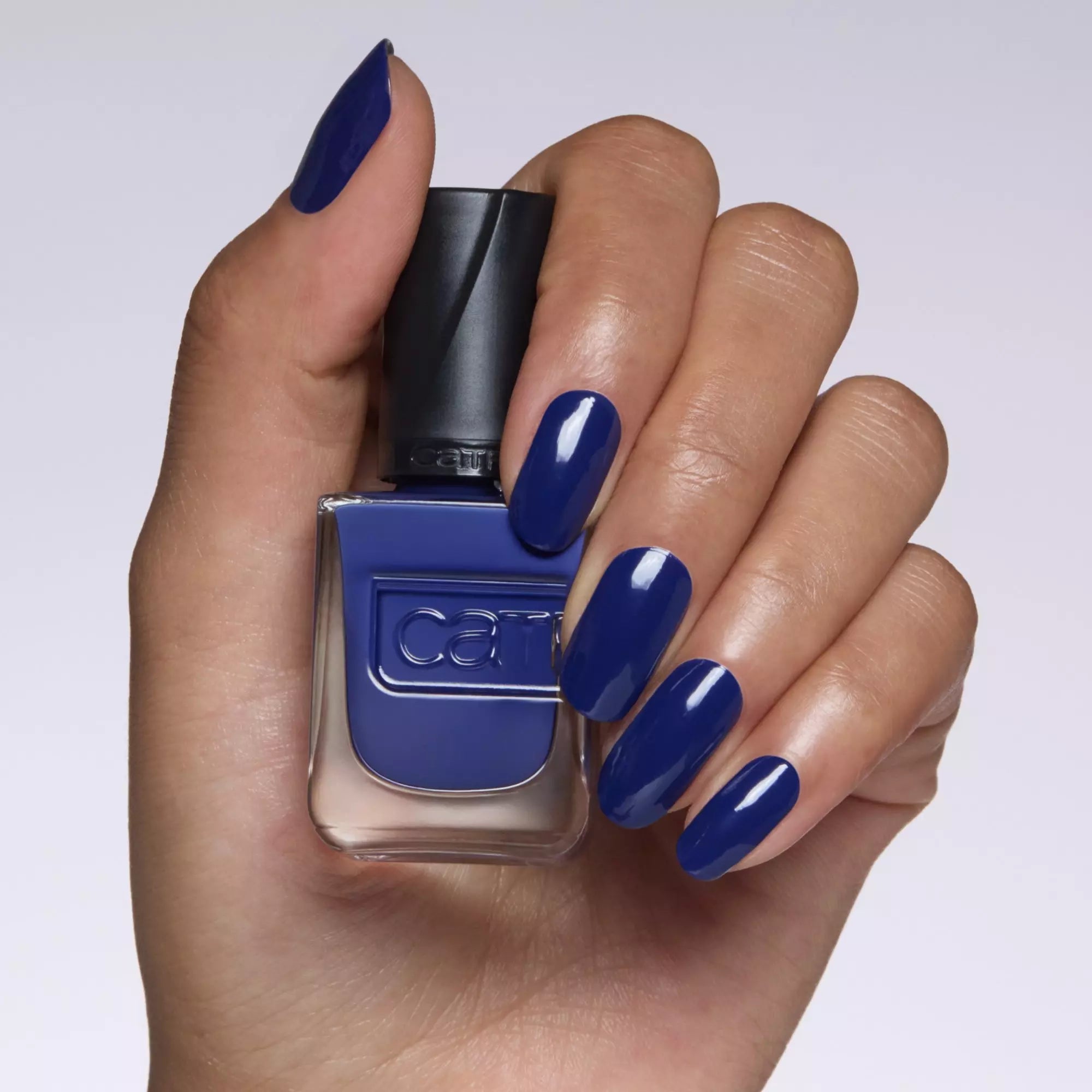 Hand with Catrice Midnight Dusk Nails Holding Gel Affair Nail Polish Bottle