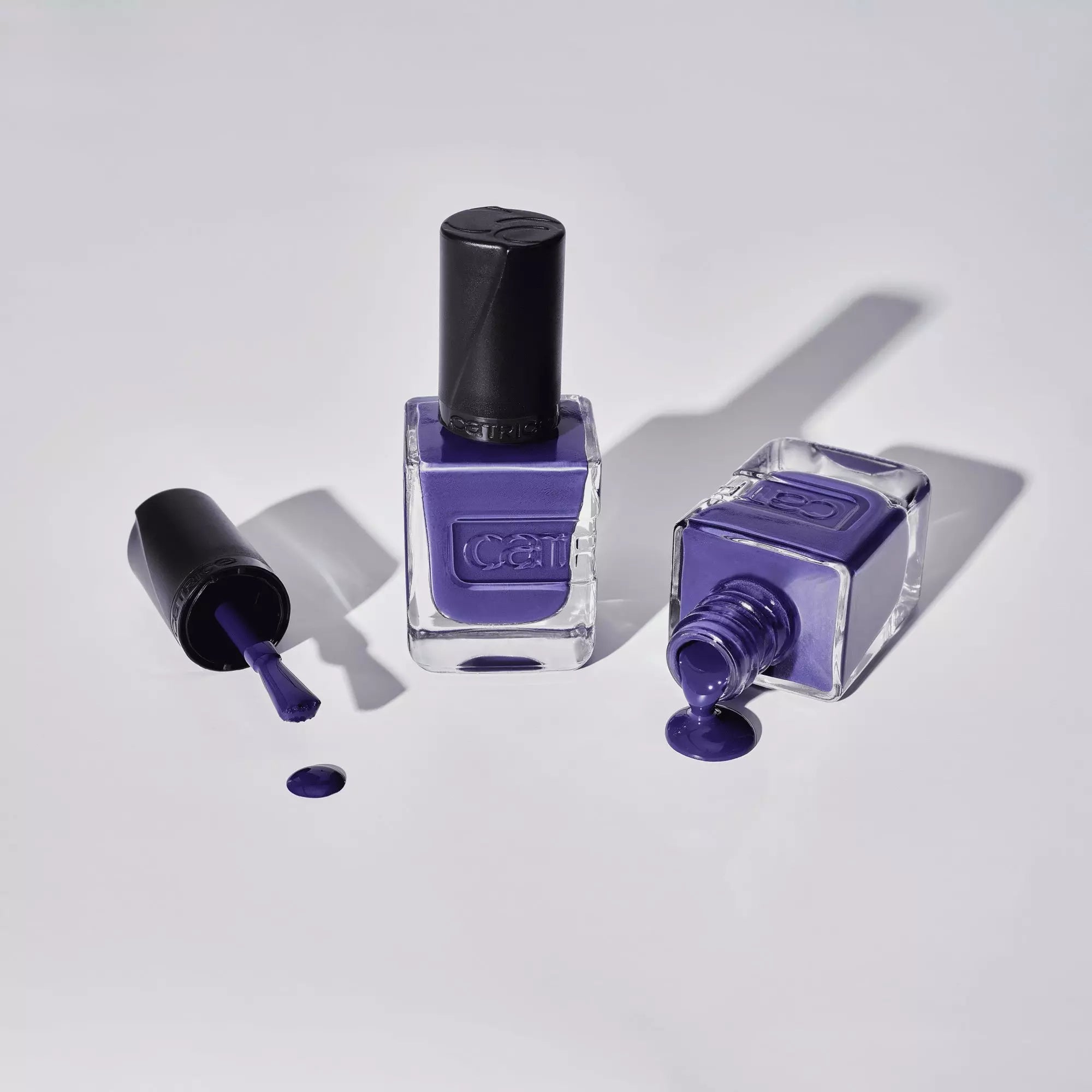Flatlay of Catrice Midnight Dusk Nail Lacquer Bottles and Dark Blue Purple Polish