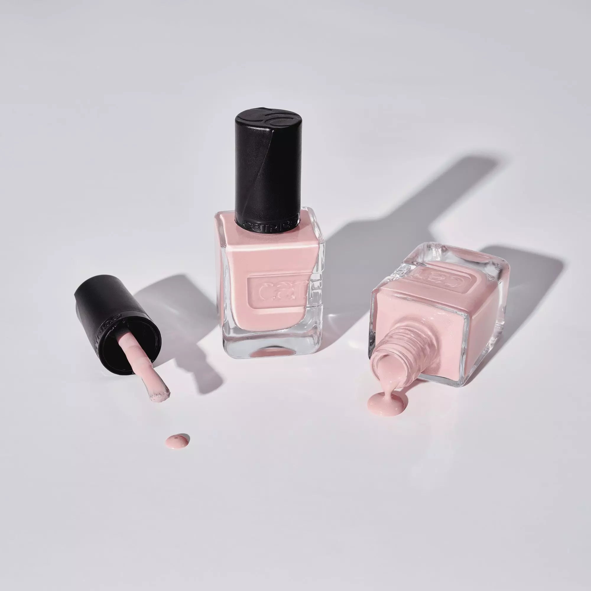 Flatlay of Catrice pale pink nail polish with bottle and polish spill