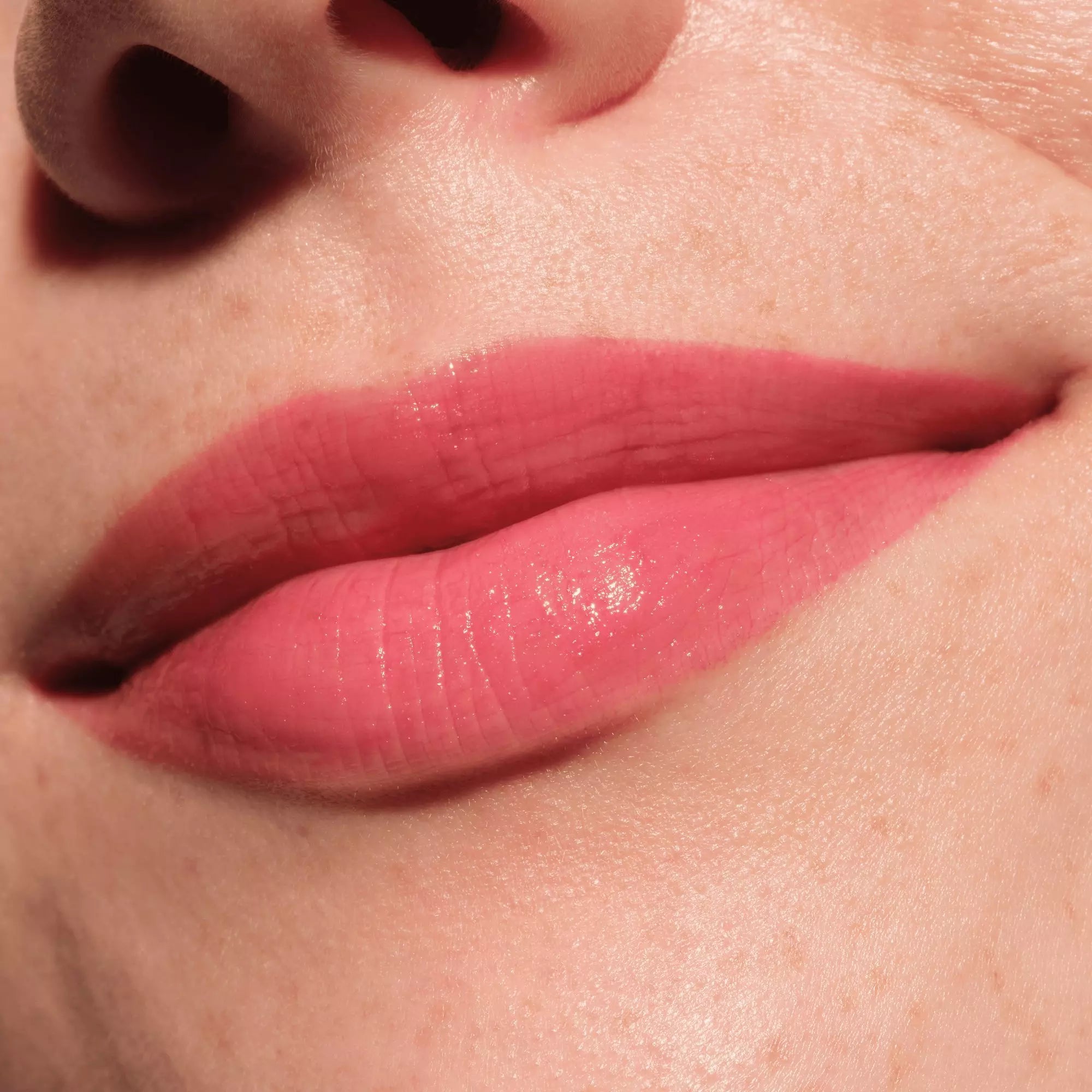Close-up of lips wearing Catrice 050 Tropic Like It’s Hot with glossy red tint Lip plumper 