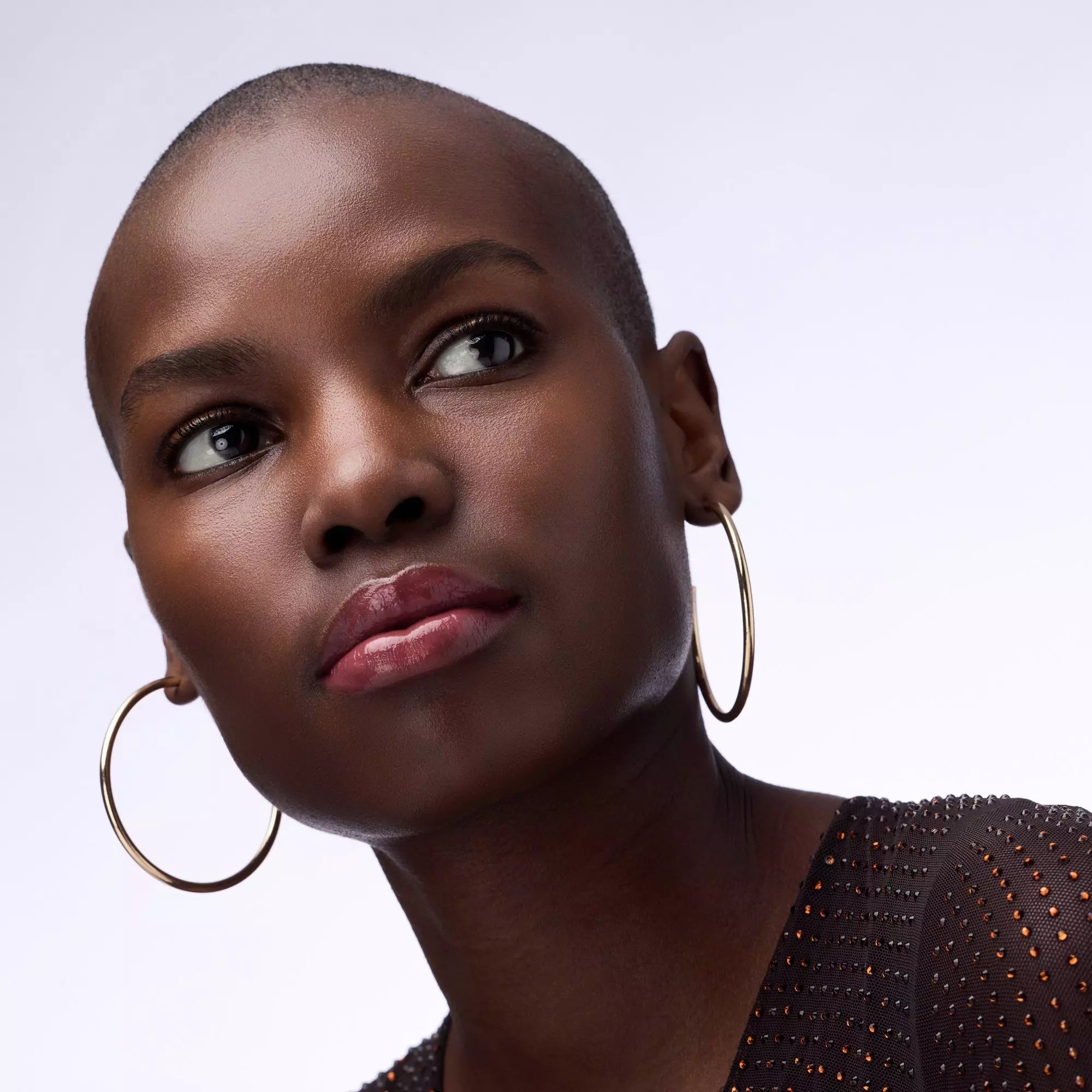 Model wearing Catrice Lip Plumper 040 with glossy mauve berry lips