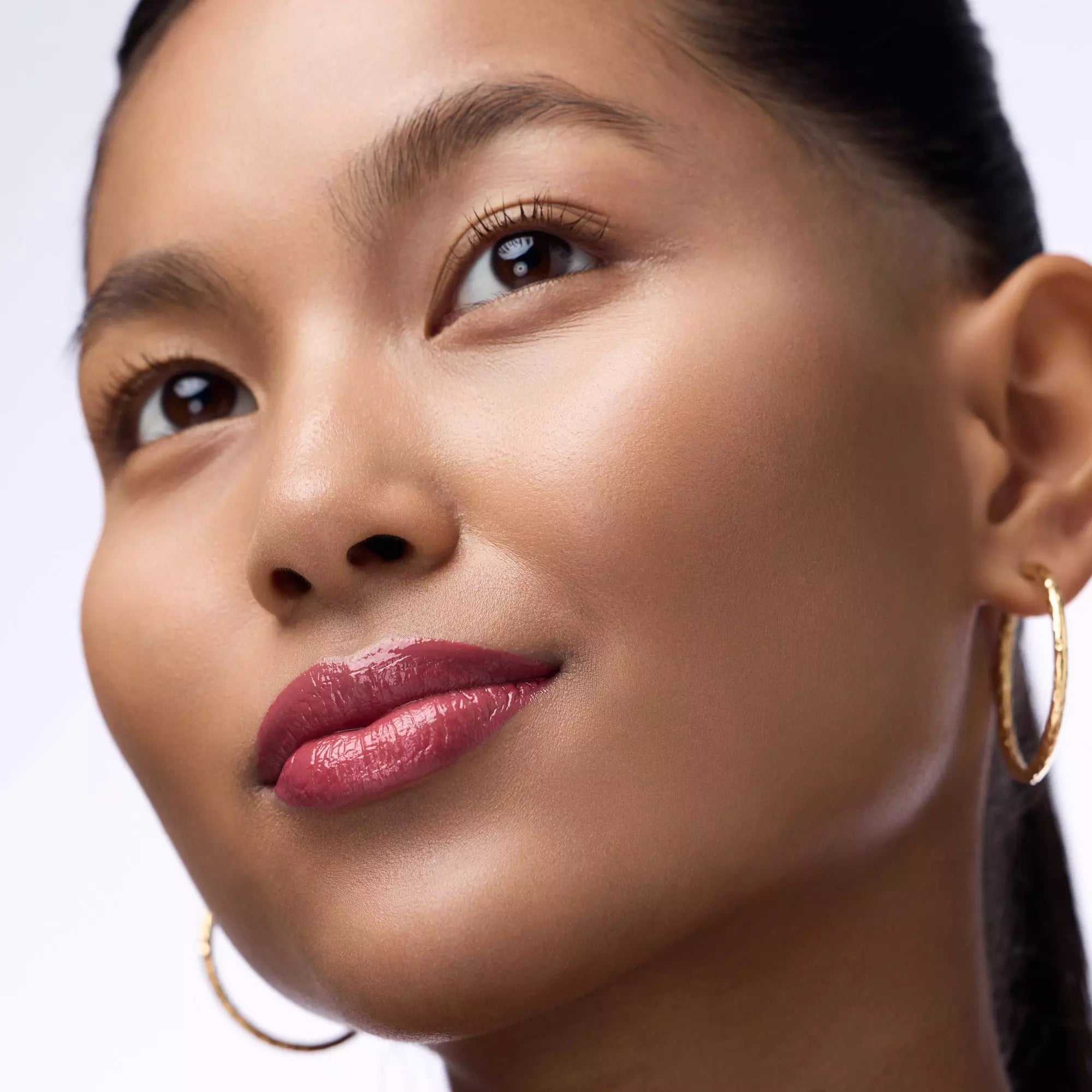 Model wearing mauve berry Catrice plumping gloss 040 Call Nine Wine