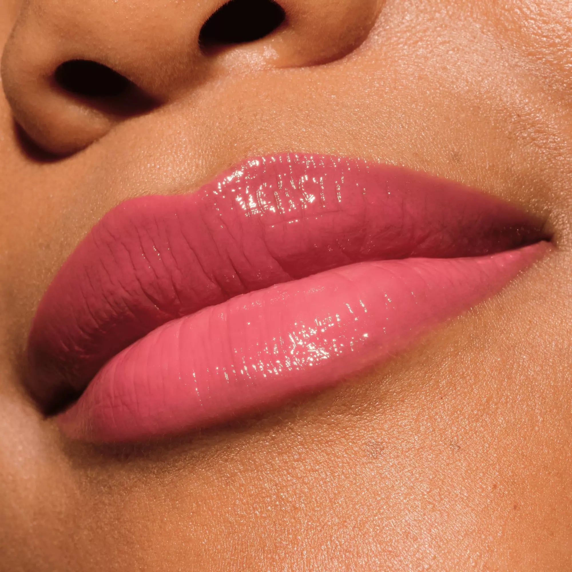 Glossy berry pink lip swatch of Catrice 040 on dark skin tone