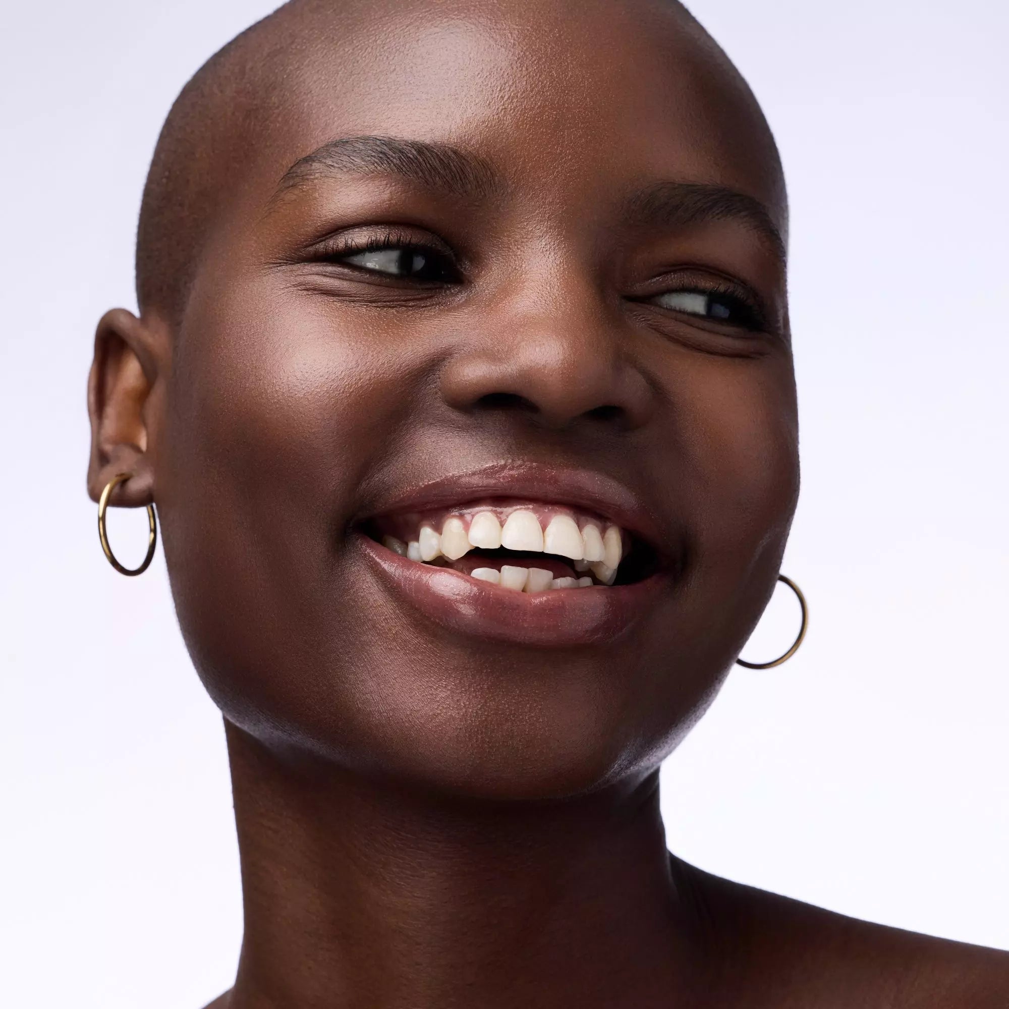 Model with natural makeup showcasing glossy brown lip colour