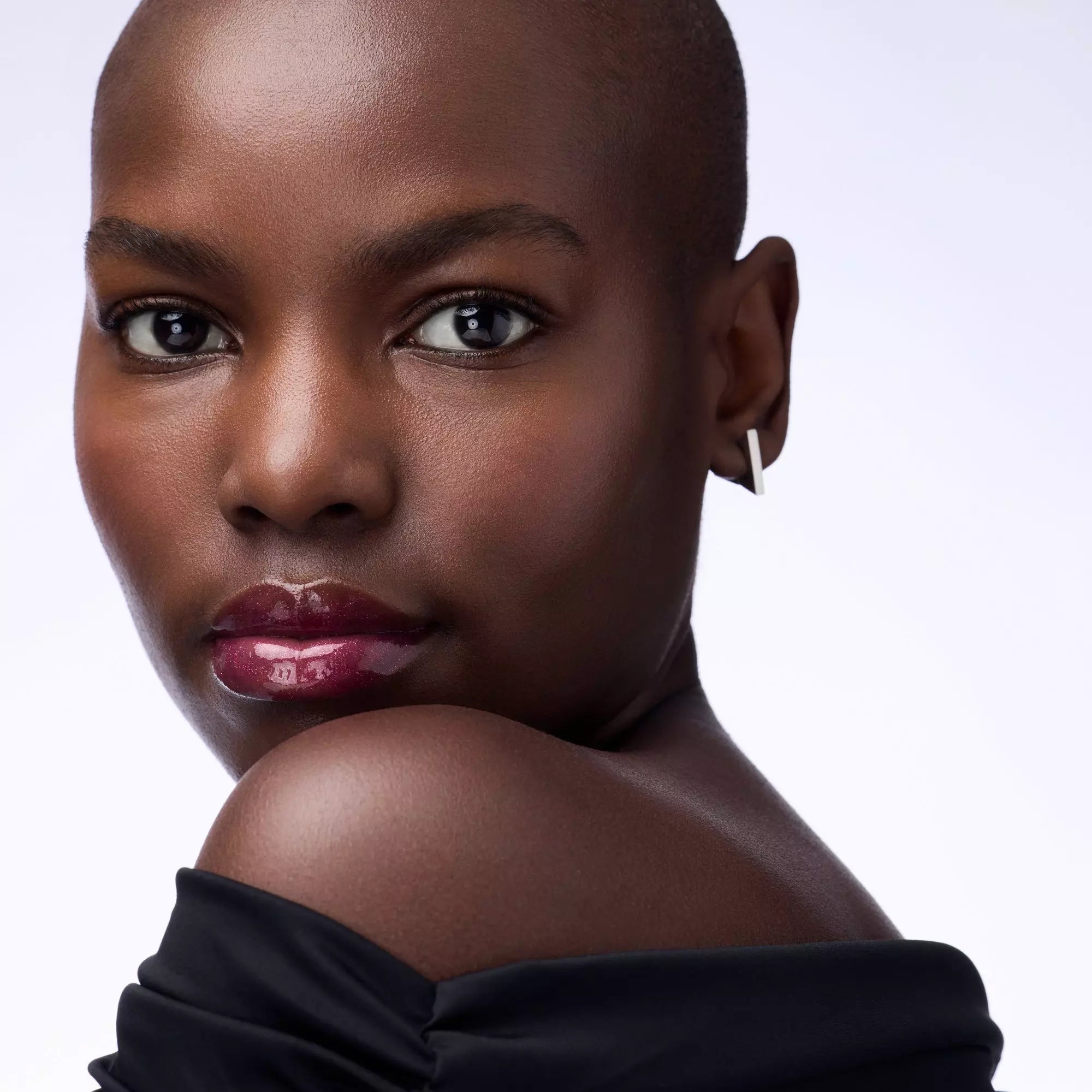 Model wearing Catrice Self Love & Glitter lip gloss – deep skin tone