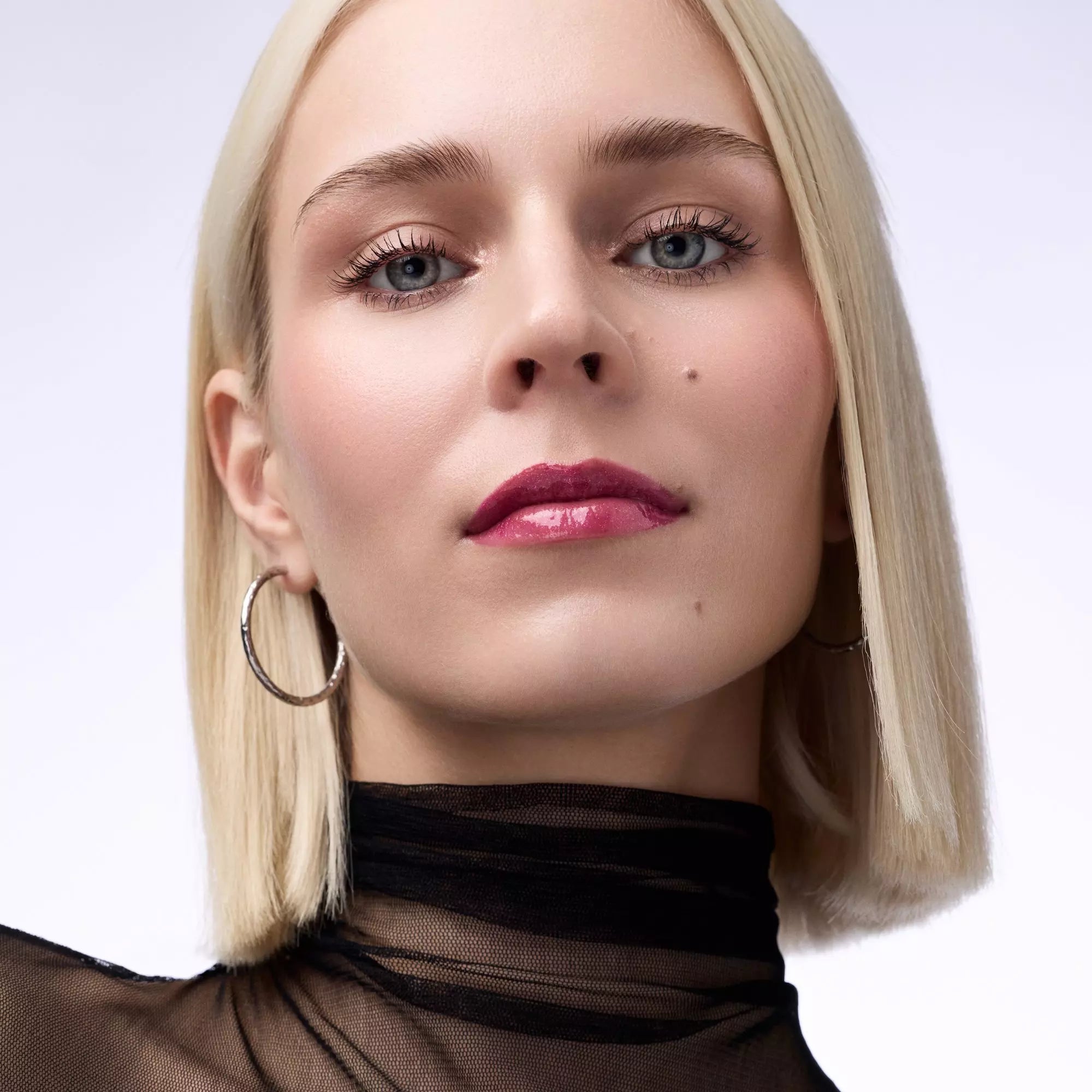 	Fair-skinned model wearing Catrice Self Love & Glitter lip gloss