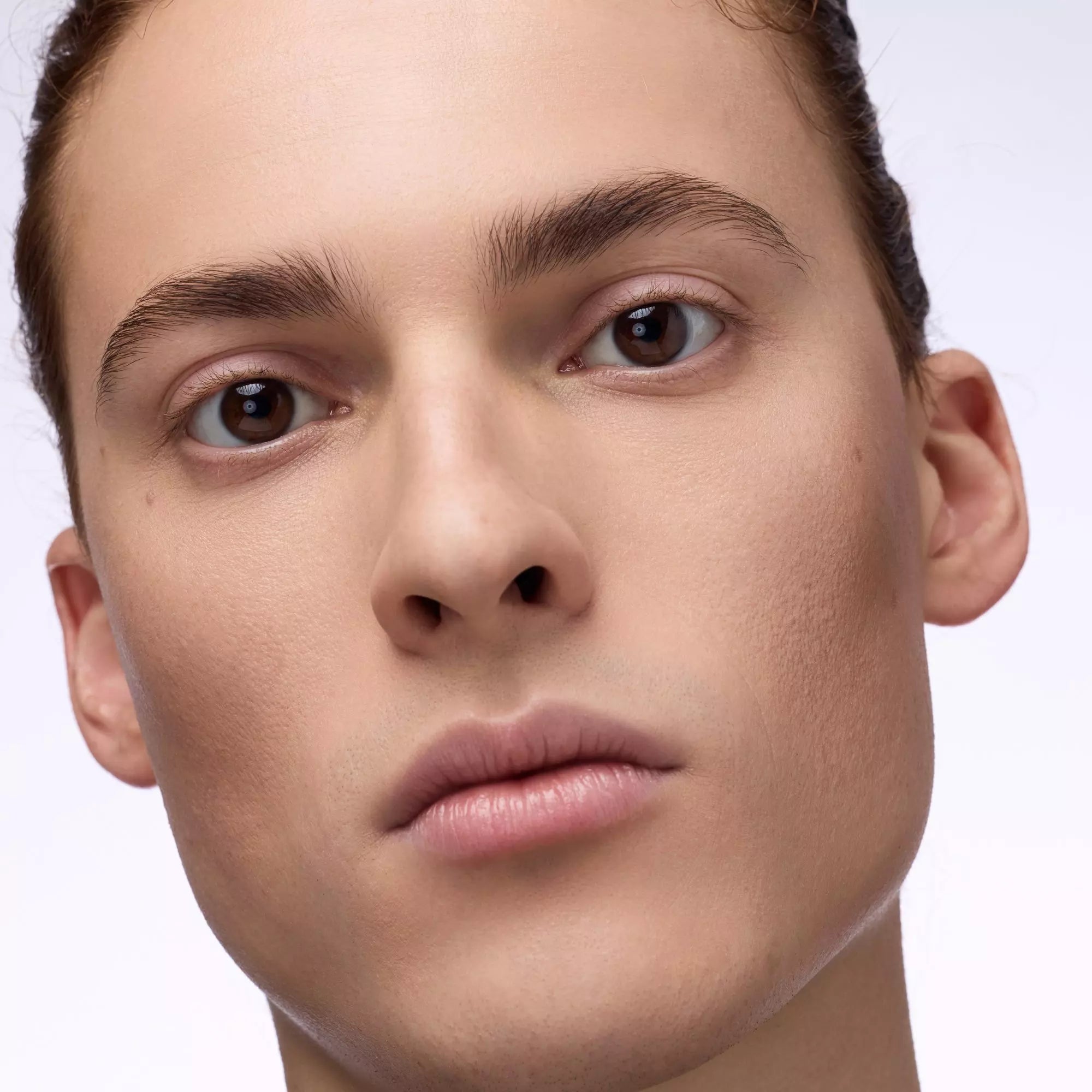 Close-up of male model wearing Catrice 010 Fair Light glow stick