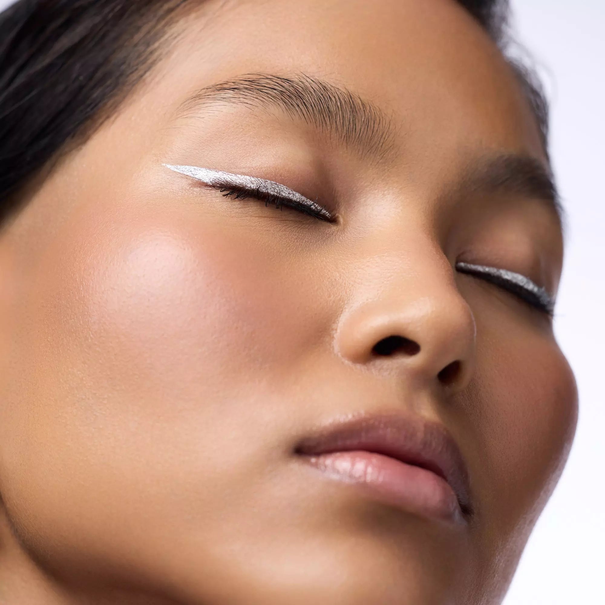 Dark Skinned Model with silver eyeliner wing for a graphic eye look