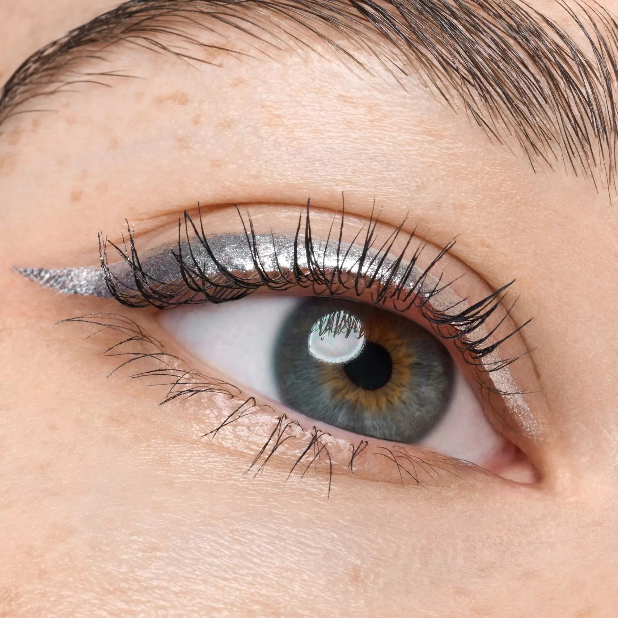 Eyelid view of brunette model wearing Catrice silver liquid eyeliner