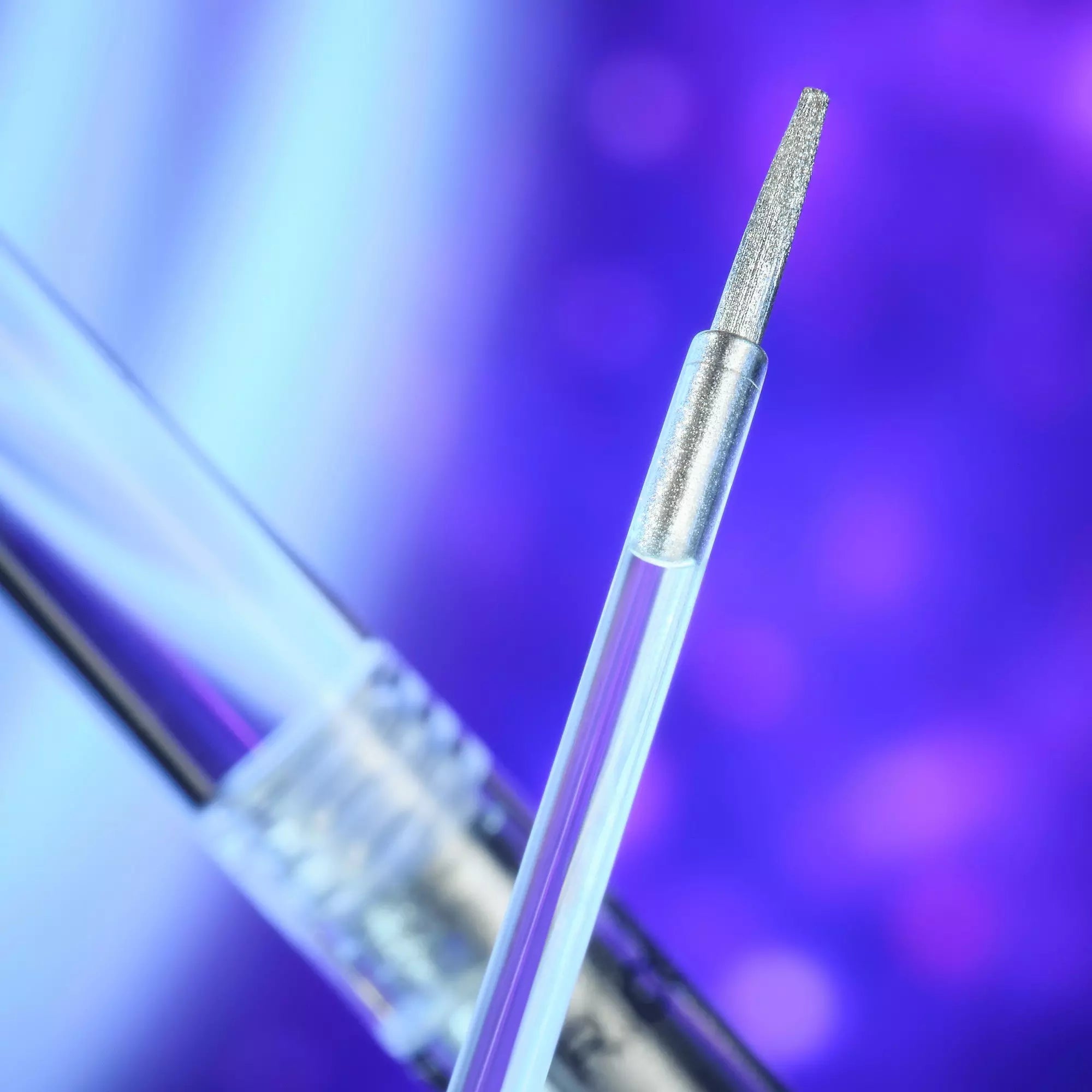 Brush tip dipping into eyeliner under purple cosmic lighting