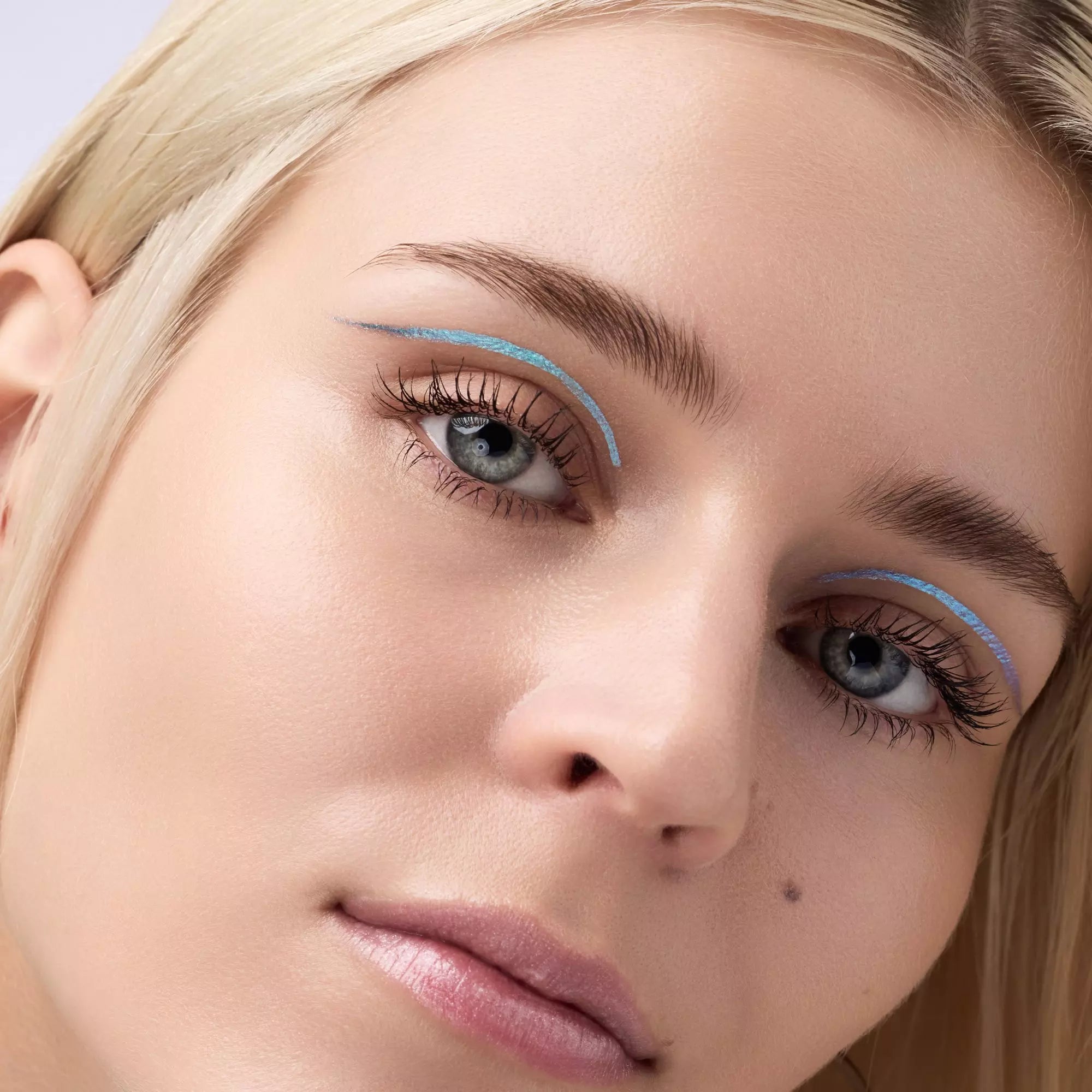 Model with fair skin wearing Catrice Space Glam purple-blue eyeliner