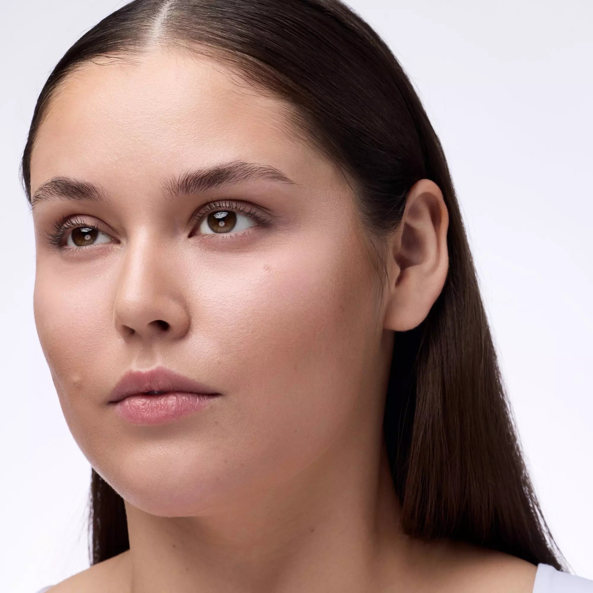 Model with minimal makeup showing brightened under-eye area using Light Rose powder