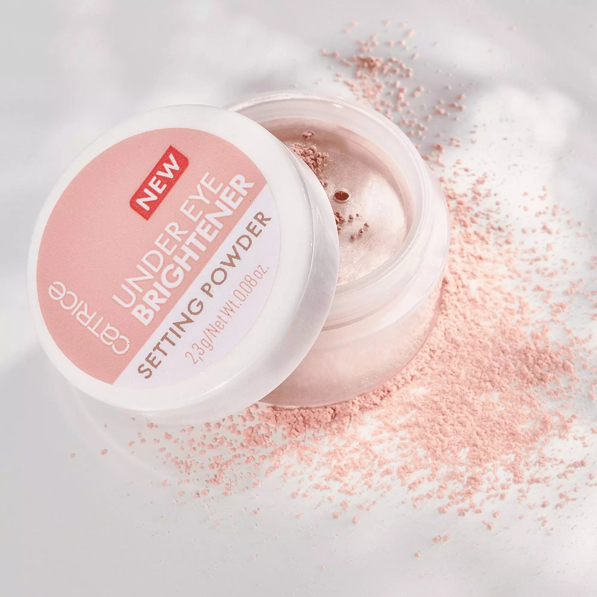 Open jar of Catrice Under Eye Brightener Light Rose with powder scattered around