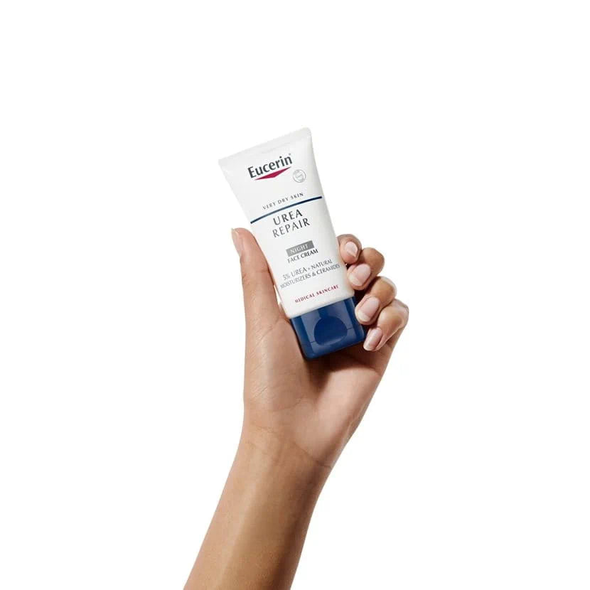 Smiling woman holding Eucerin UreaRepair Night Face Cream tube