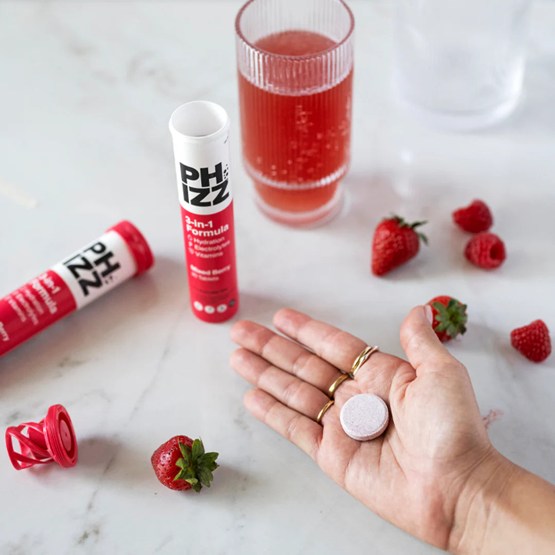 Phizz Mixed Berry tube with glass on table — hydration and electrolytes effervescent drink