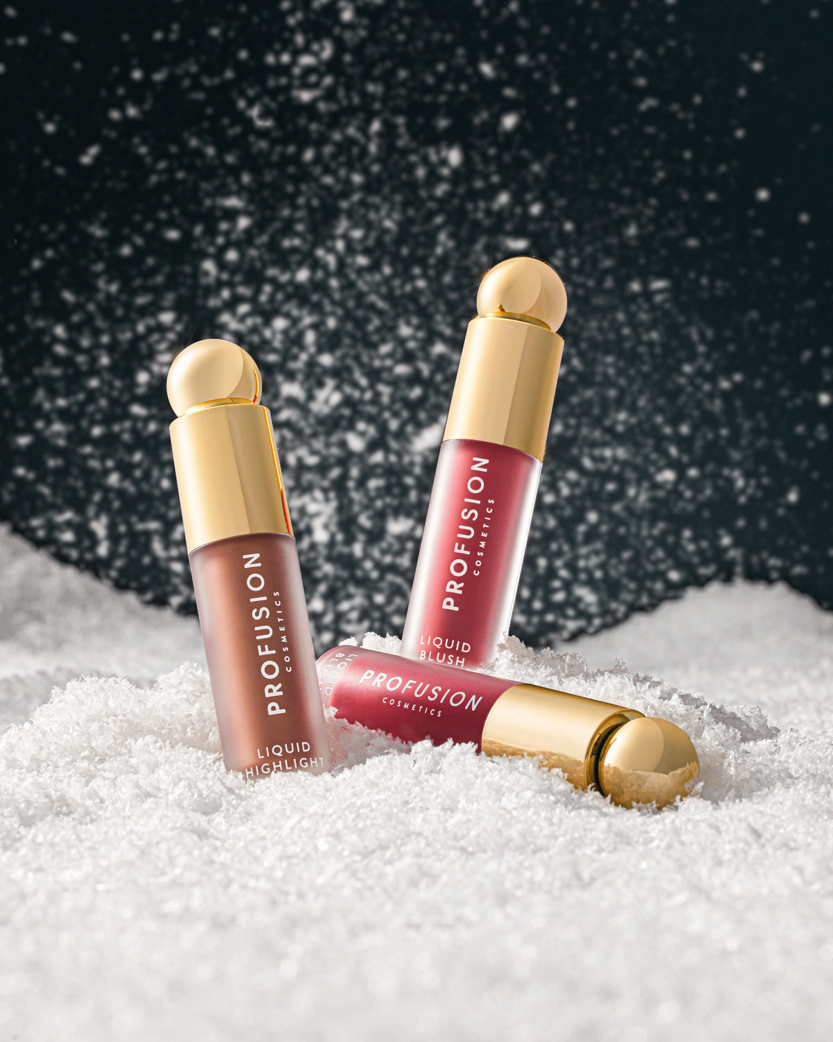 Profusion Glow Get Em Liquid Blush & Highlighter Trio in pink and champagne shades displayed in a festive christmas setting
