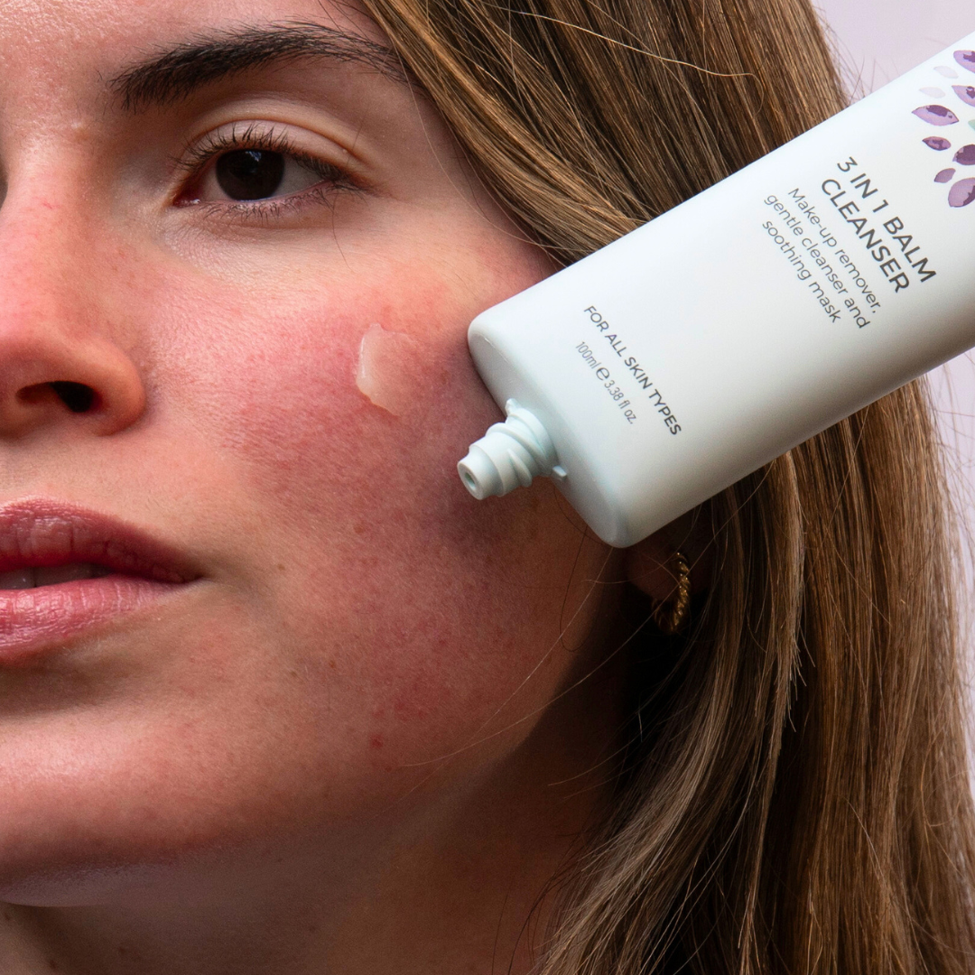 Woman using Rosalique anti-redness cleanser on cheek for calming effect