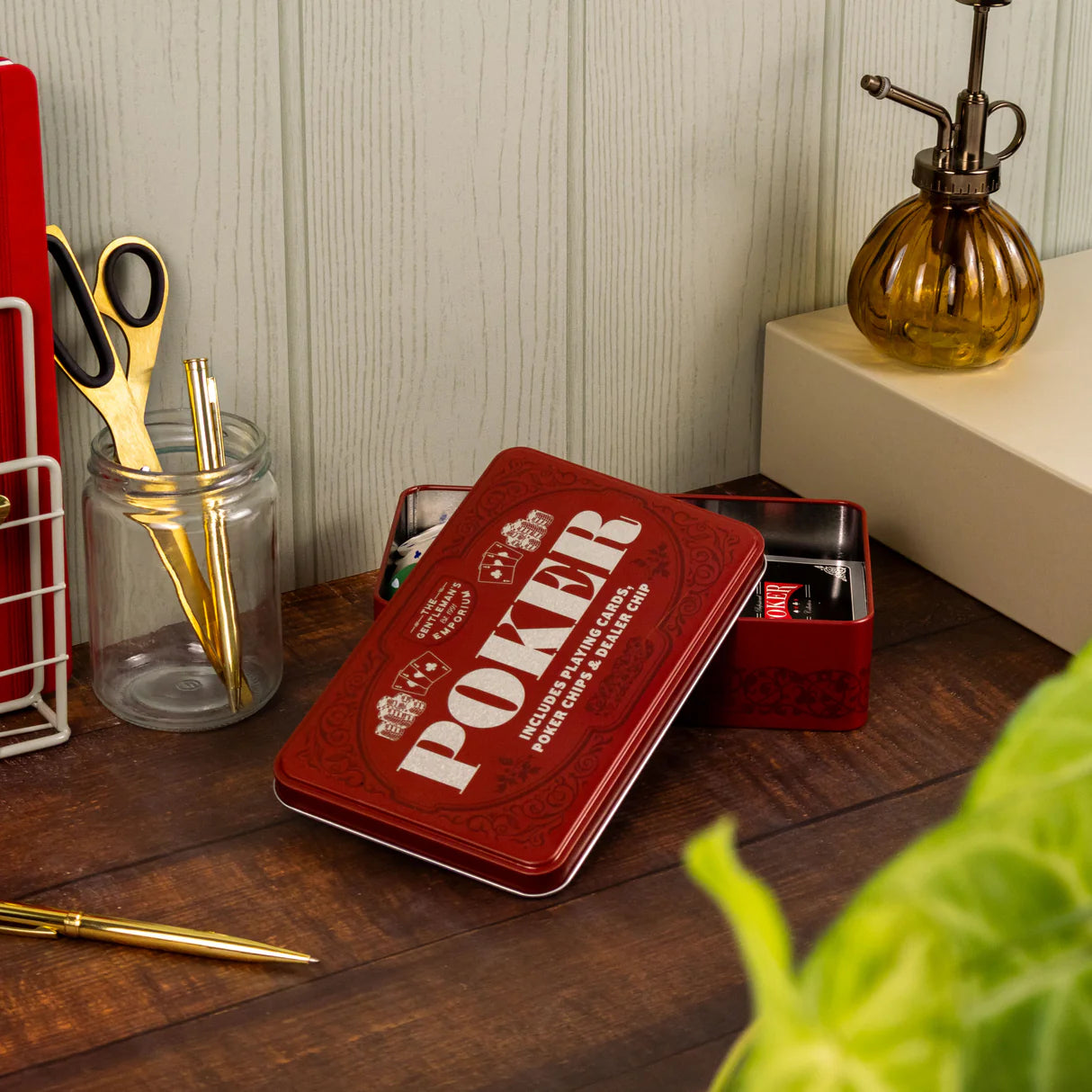 Styled poker tin with chips and cards on wooden surface — thoughtful gift for poker nights