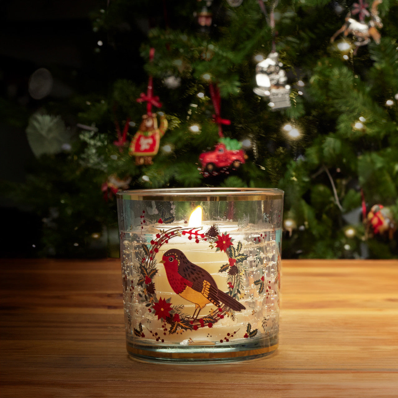 Close-up of Robin LED candle jar lit — robin and holly design illuminated for warm Christmas ambience.