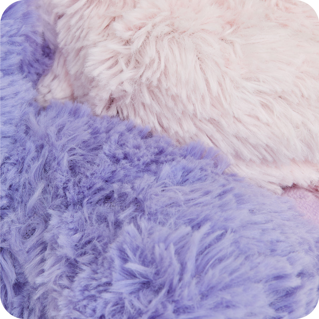 Warmies plush close-up texture — purple unicorn fur and lavender-fill detail on microwavable weighted toy.